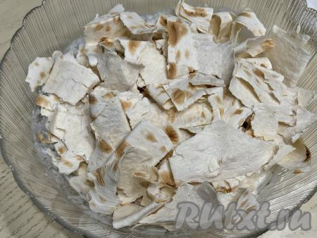 Остальной лаваш порвать руками (или нарезать кухонными ножницами) на кусочки, выложить в миску со смесью из кефира и яиц.