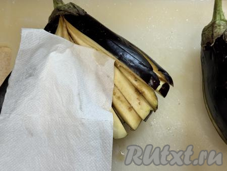 По прошествии 10-15 минут посоленные баклажаны выделят сок. Промокнуть мякоть каждого баклажана бумажным полотенцем, убирая выделившийся сок.