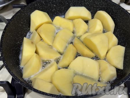 В сковороду влить растительное масло, хорошо его разогреть. Выложить дольки картошки в сковороду.