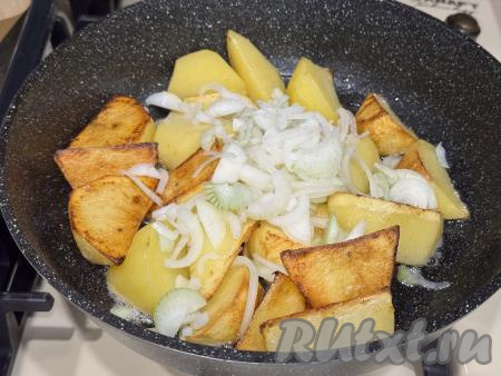 Как только картошка покроется золотистой корочкой, добавить в сковороду лук, нарезанный на полукружочки, перемешать. Сделать огонь средним и обжарить картошку с луком в течение 5 минут.&nbsp;
