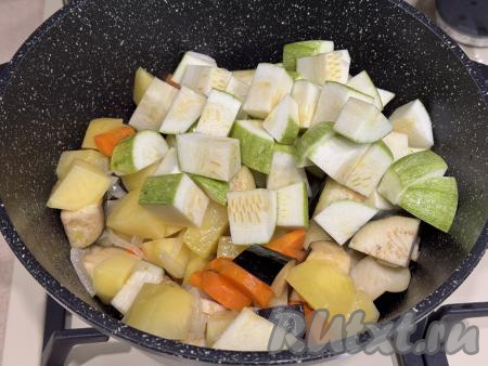 Затем к обжаренным овощам выложить баклажаны, нарезанные на средние кусочки, и 300 грамм кабачков, нарезанных на средние кубики.