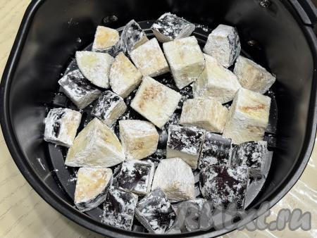Встряхнуть миску с баклажанами, чтобы овощи покрылись крахмалом со всех сторон. Баклажаны, покрытые крахмалом, выложить в чашу аэрогриля в один слой.
