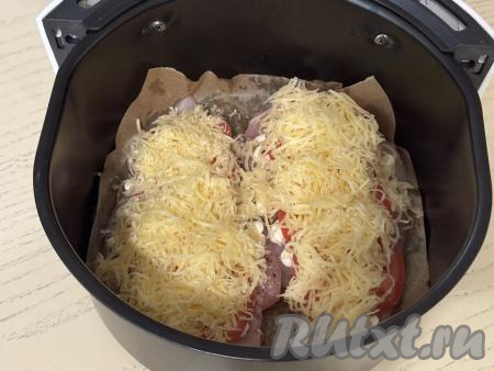 Сыр натереть на мелкой тёрке и разложить пышной шапочкой поверх каждой куриной отбивной.