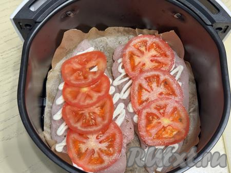 Помидор нарезать на тонкие кружочки и выложить поверх отбивных. Можно выкладывать кружочки помидора слегка внахлёст.