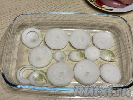 На дно жаропрочной формы (я взяла форму размером 28 сантиметров на 17 сантиметров) выложить в один слой лук, нарезанный на кольца.&nbsp;