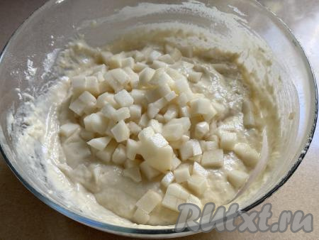 Грушу очистить от кожуры, удалить семенную коробку с семечками. Нарезать грушу на мелкие кубики, добавить в тесто, перемешать.