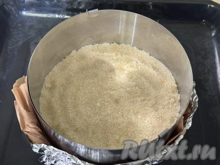 Взять разъёмную форму для выпечки диаметром 20 сантиметров, немного смазать растительным маслом. Я в качестве формы использовала кулинарное кольцо диаметром 20 сантиметров, дно сформировала из фольги, сложенной в несколько слоёв, и пергамента, получившуюся форму поставила на противень. В подготовленную форму выложить половину песочной крошки, немного утрамбовать.&nbsp;