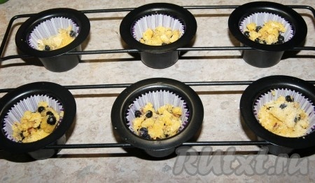 Приготовить формочки для кексов (я в каждую формочку вложила бумажный вкладыш). В каждую формочку положить кусочек теста, заполняя форму до половины объёма, и сверху присыпать немного свежими (или замороженными) ягодами.
