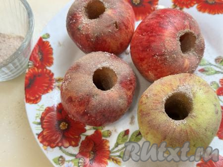 Всыпать смесь из сахара и корицы в серединку яблок. Немного смеси оставить для присыпки сверху.