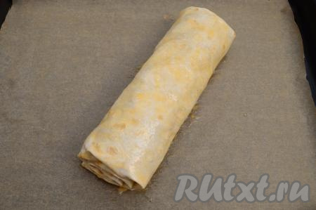 Сырое яйцо в небольшой ёмкости взболтать вилкой до однородности. Смазать при помощи кулинарной кисти поверхность рулета взбитым яйцом.