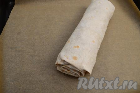 Переложить рулет из лаваша на противень, застеленный пергаментом.
