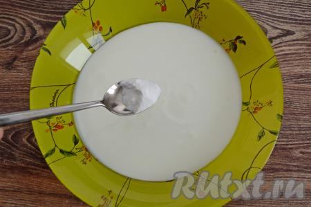 В глубокую тарелку влить кефир, всыпать соду, перемешать и оставить минут на 5.