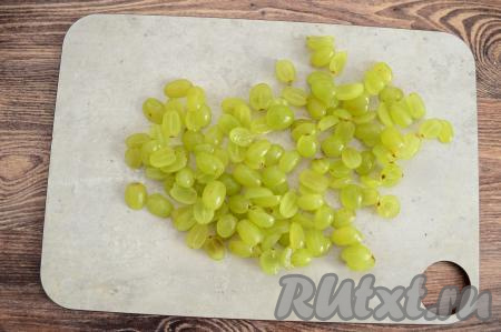 Виноград промыть водой, отделить от веточек. Желательно виноград брать без косточек, но если косточки есть, их нужно обязательно удалить. Нарезать каждую виноградинку на 2 части.&nbsp;