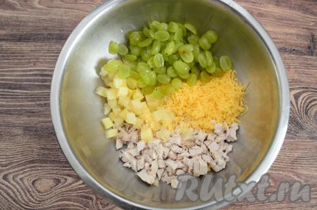 В миску с натёртым сыром добавить куриное мясо, ананасы, виноград и пропущенный через пресс чеснок. Несколько половинок винограда отложить для украшения.
