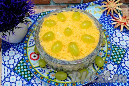 Салат "Французский салат" выложить в салатник, в котором вы будете подавать его к столу. Сверху присыпать отложенным ранее натёртым сыром. Украсить половинками винограда в виде цветочка и можно подавать к столу.