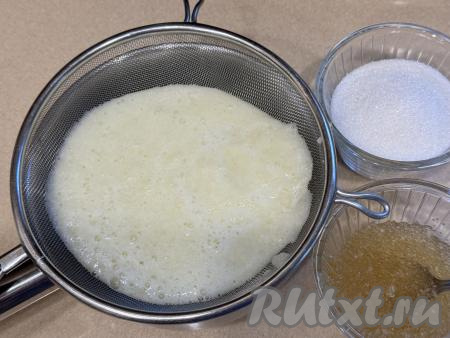 Взять небольшую кастрюлю, поверх неё поставить сито. Выложить в сито пюре из дыни. С помощью ложки перетереть пюре из дыни в кастрюлю.