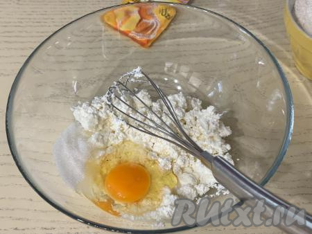 В достаточно глубокую миску выложить творог, размять вилкой, добавить яйцо и сахар.&nbsp;