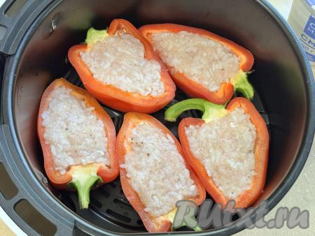 Половинки перца, фаршированные мясным фаршем и рисом, выложить на дно чаши аэрогриля.&nbsp;