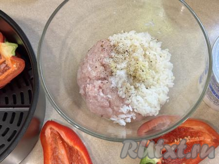 В миске соединить мясной фарш, отваренный рис, добавить соль и специи по вкусу.