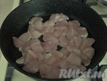 Мясо курицы промыть водой, обсушить, нарезать на средние кубики, посолить. В сковороду влить растительное масло, хорошо разогреть, выложить куриное мясо.