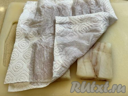 Размороженные кусочки минтая переложить на разделочную доску и обсушить бумажными полотенцами.