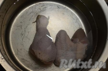 Части курицы (у меня - крылышко и ножка) промыть водой, выложить в кастрюлю, залить 2 литрами воды и поставить на сильный огонь. После того как вода в кастрюле закипит, сразу убрать с поверхности бульона образовавшуюся пену, уменьшить огонь, варить минут 30 (до готовности мяса). Снять кастрюлю с огня.