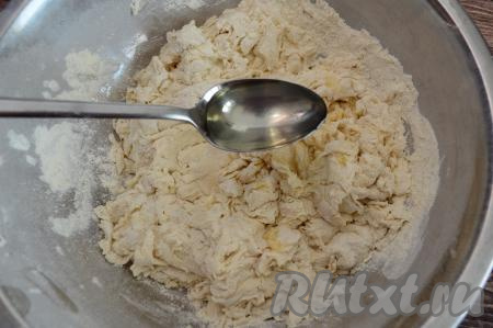 Начать замес теста столовой ложкой. Как только тесто будет трудно перемешивать ложкой, влить в тесто растительное масло. Вмешать масло в тесто и продолжить замес уже руками.