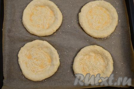 Таким образом сформировать все 6 заготовок узбекских лепёшек, не забывая сделать на плоской части каждой заготовки наколы вилкой. Затем каждую лепешку смазать взболтанным сырым яйцом и присыпать сверху кунжутом.