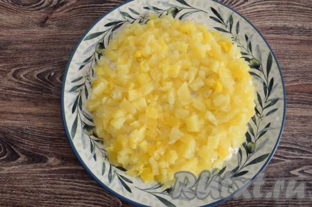 Поверх мяса разместить ровный слой нарезанных ананасов, покрывая куриный слой и сверху и с боков.