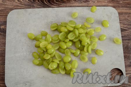 Виноград отделить от веточек, промыть водой, немного обсушить, разрезать пополам. Если в винограде есть косточки, тогда их обязательно нужно вынуть.