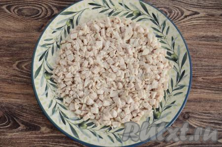 Остывшее куриное филе нарезать на небольшие кубики. На плоскую большую тарелку (я взяла тарелку диаметром 26 сантиметров) выложить куриное мясо в виде круга.