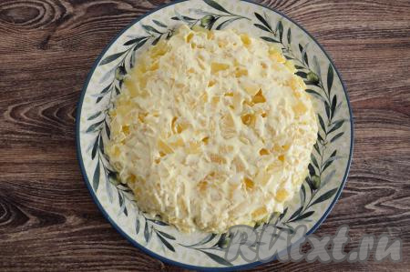 Сверху на ананасы нанести небольшим слоем майонез.