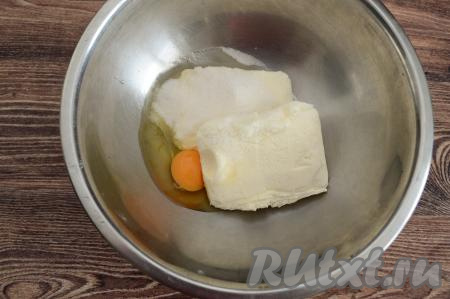 В глубокую миску выложить творог, вбить сырое яйцо, всыпать сахар.