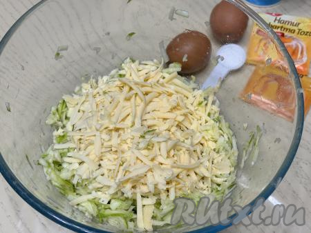 В миску выложить кабачковую массу, отжатую от сока, добавить сыр, натёртый на крупной тёрке.&nbsp;