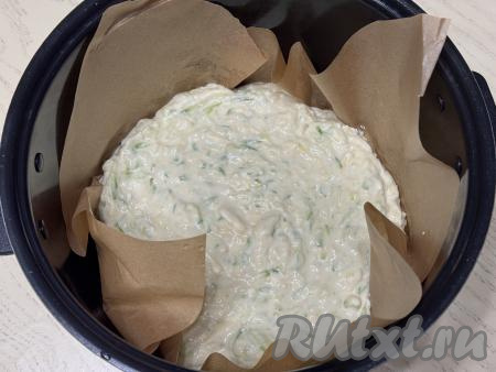 Чашу мультиварки застелить пергаментом так, чтобы он закрывал и бока чаши. Смазать пергамент растительным маслом, выложить тесто, разровнять. Установить чашу в мультиварку. Закрыть крышку, выставить режим "Выпечка" на 1 час 30 минут. Готовить запеканку из кабачков до звукового сигнала.