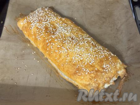 Выпекать рулет с колбасой и сыром в духовке, разогретой до 200 градусов, минут 20-25 (до подрумянивания слоёного теста).