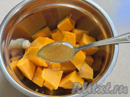 В миску с кусочками тыквы влить мёд и растопленное сливочное масло.