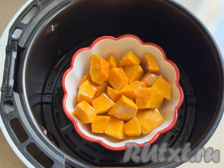 Переложить кусочки тыквы, покрытые маслом и мёдом, в керамическую или силиконовую форму, поставить в чашу аэрогриля. Желательно, чтобы тыква располагалась в форме в один слой.