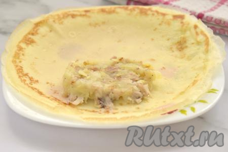 После того как все блины будут пожарены, можно приступать к фаршировке. С одной стороны блина выкладываем примерно 2 столовых ложки начинки из картошки и курицы, немного отступая от краёв блинчика. Затем подворачиваем боковые края блина на начинку, и, начиная со стороны с начинкой, сворачиваем блин в достаточно плоский рулет.