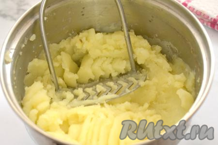 С помощью толкушки разминаем картофель вместе с 70 миллилитрами воды, оставшимися в кастрюле.