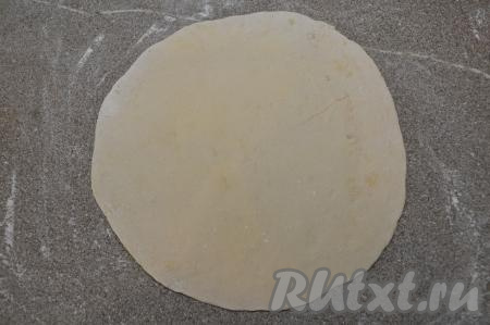 На припылённом мукой столе раскатать вначале один шарик теста в круг толщиной 2 миллиметра и диаметром около 24 сантиметров.