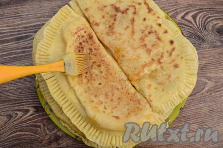 Готовые чуду с тыквой со сковороды переложить на плоскую тарелку. Горячие лепёшки сразу щедро смазать с двух сторон растопленным сливочным маслом, промазывая обязательно и края чуду. Поместить на сухую разогретую сковороду следующие 2 заготовки чуду с тыквой, жарить до подрумянивания с двух сторон. Выложить готовые лепёшки на тарелку поверх двух первых чуду, смазанных маслом. Их, как и последующие лепёшки, нужно будет щедро смазывать растопленным маслом только с одной (верхней) стороны. Постепенно пожарить все чуду. Благодаря маслу, лепёшки становятся нежнейшими.