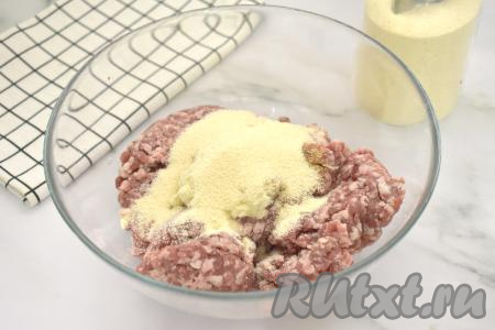 В миску с фаршем, луком и чесноком всыпаем манную крупу.