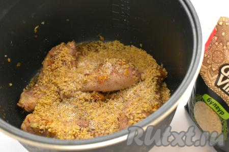 После окончания режима мультиварки "Жарка" к овощам и куриным ножкам&nbsp;всыпаем булгур (предварительно промывать его не нужно), добавляем соль, учитывая, что голени мы уже солили, и специи (в качестве специй я использовала чёрный молотый перец).