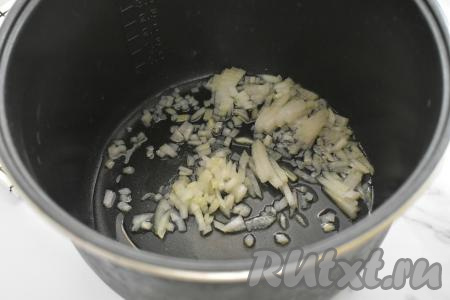 Очищаем морковку и лук. Наливаем в чашу мультиварки растительное масло, выставляем режим "Жарка" на 20 минут. Когда масло разогреется (прозвучит звуковой сигнал), выкладываем в чашу мультиварки мелко нарезанный лук, обжариваем его 3 минуты (до прозрачности), не закрывая крышку мультиварки и периодически перемешивая.