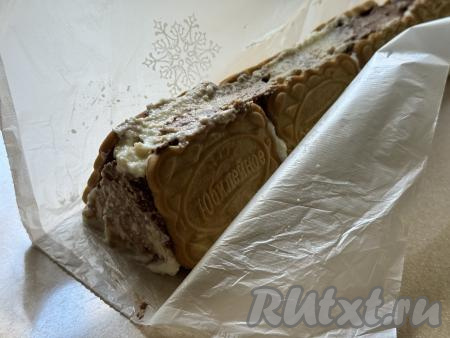 Придерживая целлофановый пакет с двух сторон, сложить домик из печенья. Творожная начинка останется внутри домика.