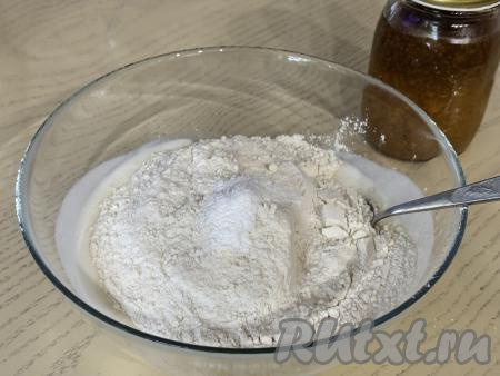 Затем в смесь кефира и соды добавить соль, разрыхлитель, всыпать половину муки.