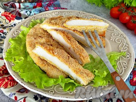 Запечённое куриное мясо, благодаря панировке из яйца и сухарей, получается мягким, достаточно сочным, его с удовольствием едят и взрослые и дети. При подаче его можно дополнить любым гарниром на ваш выбор.