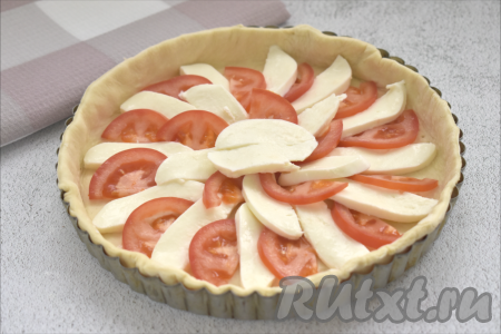 Распределяем по тесту, чередуя, кусочки помидоров и моцареллы.