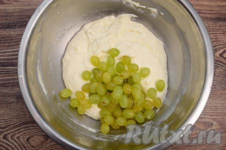 Затем в миску с получившейся творожной массой выложить обсушенный виноград. Виноград без косточек можно добавлять целиком. Если же в винограде есть косточки, тогда нужно будет разрезать каждую виноградинку вдоль и удалить косточки.